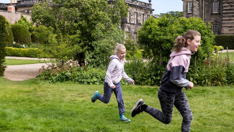 children running through spring gardens at Seaton Delaval Hall